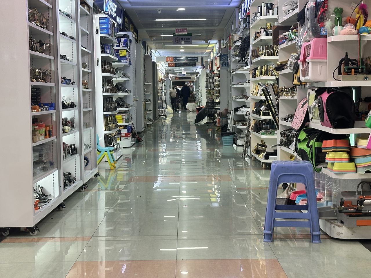 Luggage and bags displayed along a Yiwu market aisle